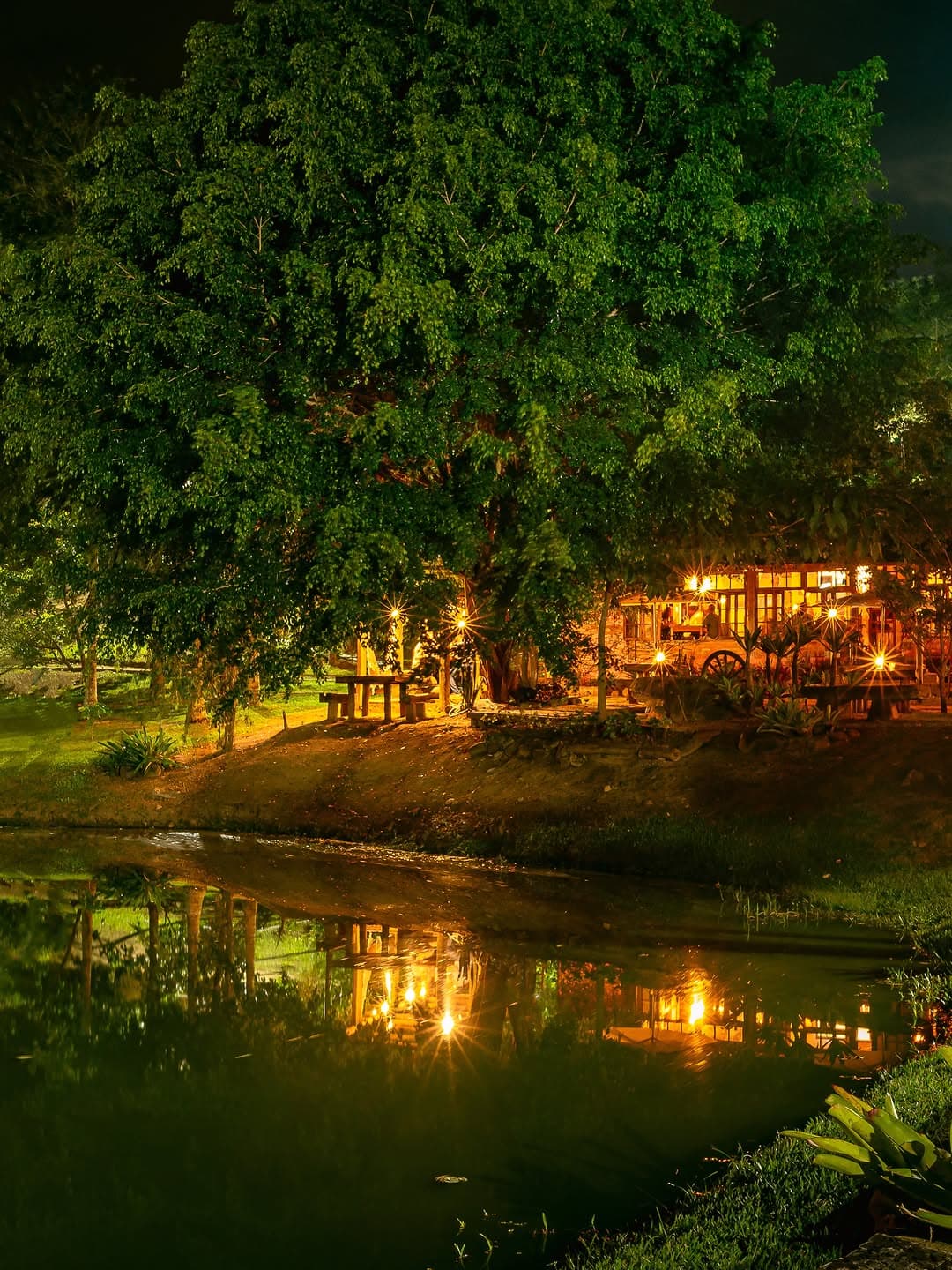 Casa do Lago iluminada ao lado do lago durante a noite